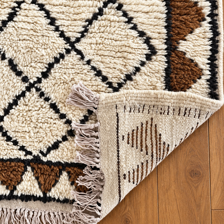 Folded detail of handmade Moroccan ivory walnut and black runner rug with fringe