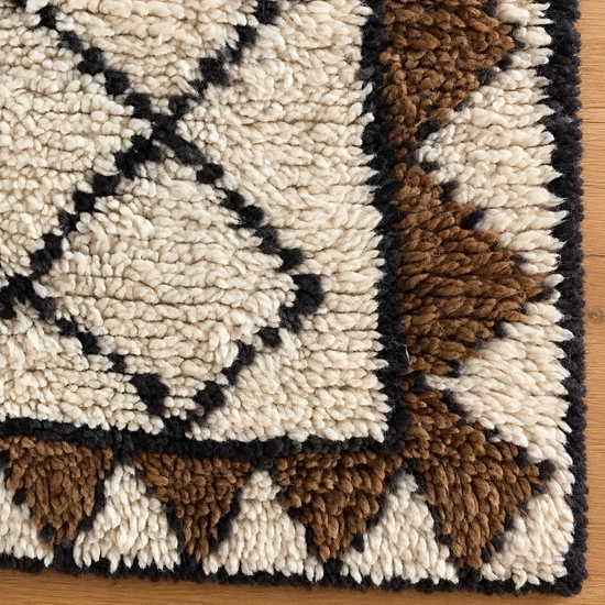 Close-up texture of handmade Moroccan ivory walnut and black plush runner rug